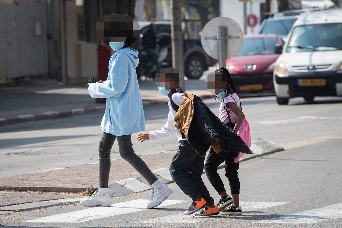 Asylum seeker children cross the street in south Tel Aviv, March 17, 2020. (Oren Ziv) Asylum seeker children cross the street in south Tel Aviv, March 17, 2020. (Oren Ziv)