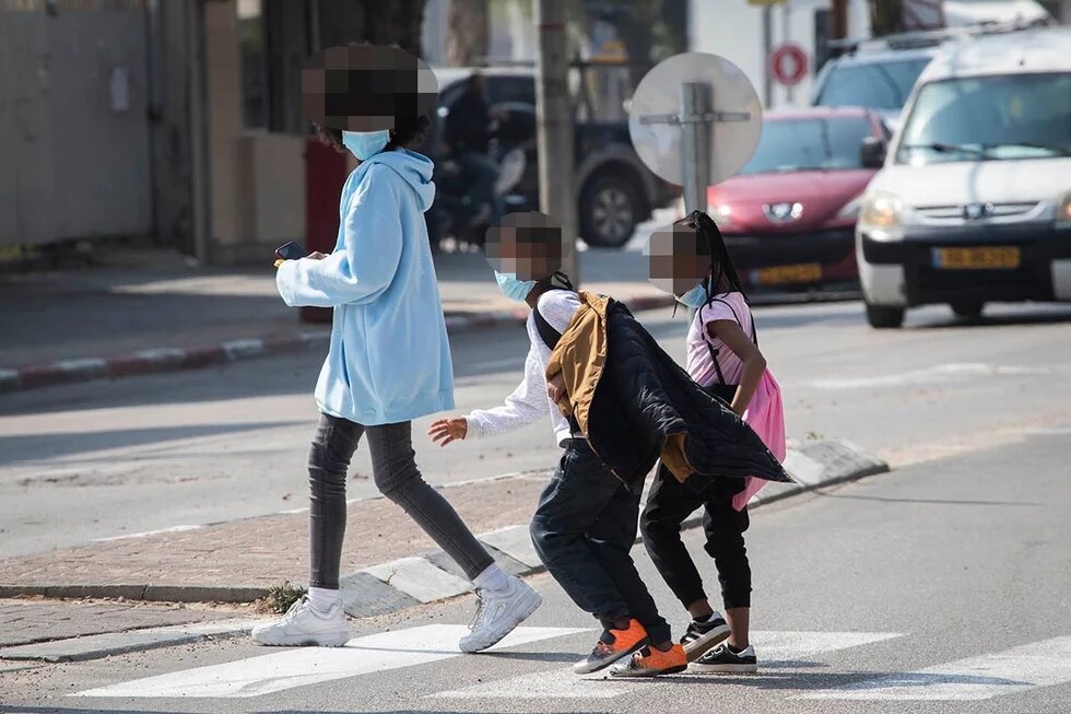 Asylum seeker children cross the street in south Tel Aviv, March 17, 2020. (Oren Ziv)